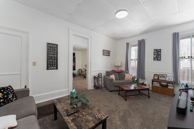 living room featuring a paneled ceiling, carpet floors, and plenty of natural light