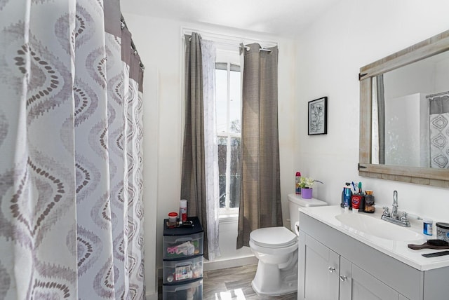 bathroom with vanity, curtained shower, and toilet