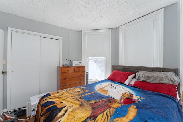 bedroom with a paneled ceiling and a closet