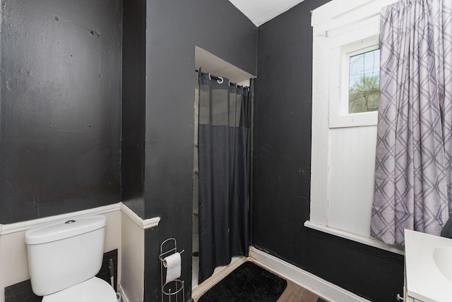 bathroom with a shower with shower curtain and toilet
