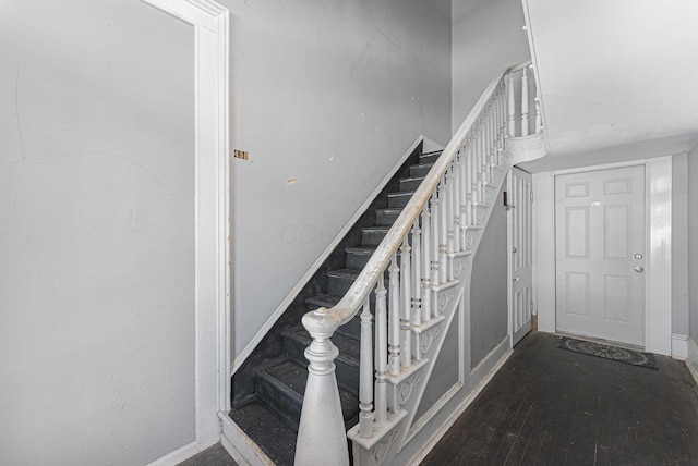 staircase with baseboards and wood finished floors