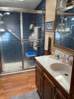 bathroom featuring an enclosed shower and vanity