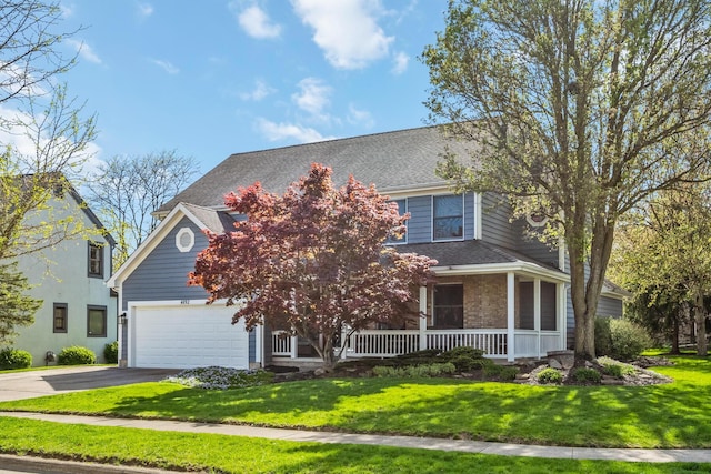 view of front of home featuring covered porch, driveway, a shingled roof, and a front yard