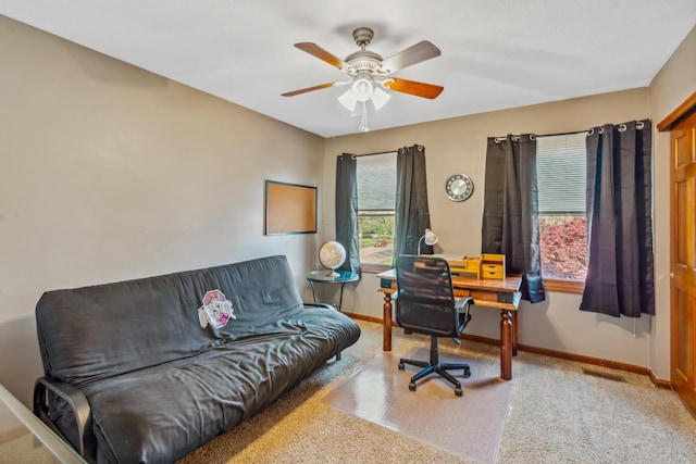 carpeted office space featuring baseboards, ceiling fan, and visible vents