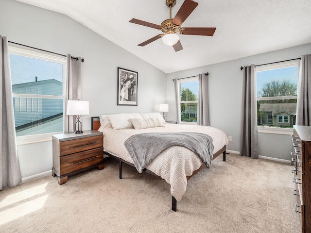 bedroom with light colored carpet, lofted ceiling, a ceiling fan, and baseboards
