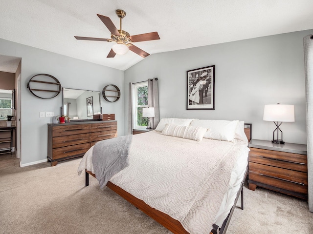 bedroom featuring light carpet, vaulted ceiling, baseboards, and a ceiling fan