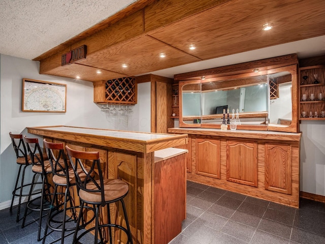 bar featuring baseboards, recessed lighting, and wet bar
