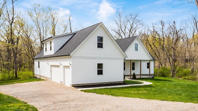 modern farmhouse with gravel driveway, roof with shingles, a front lawn, and a garage