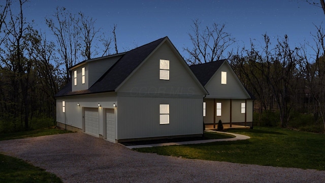 view of side of property featuring a lawn, driveway, and roof with shingles