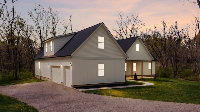 view of front facade with a garage, a shingled roof, a front yard, and aphalt driveway