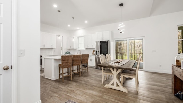 dining space featuring baseboards, wood finished floors, and recessed lighting