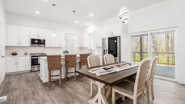 dining area featuring light wood-style flooring and recessed lighting