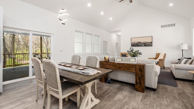 dining area featuring recessed lighting, light wood-style flooring, visible vents, and high vaulted ceiling