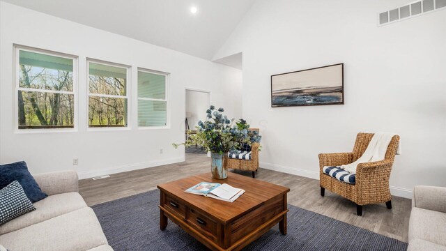 living area featuring wood finished floors, visible vents, and baseboards