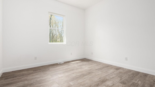 empty room featuring baseboards and wood finished floors