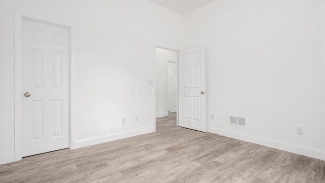 unfurnished bedroom featuring baseboards, light wood-style floors, and visible vents