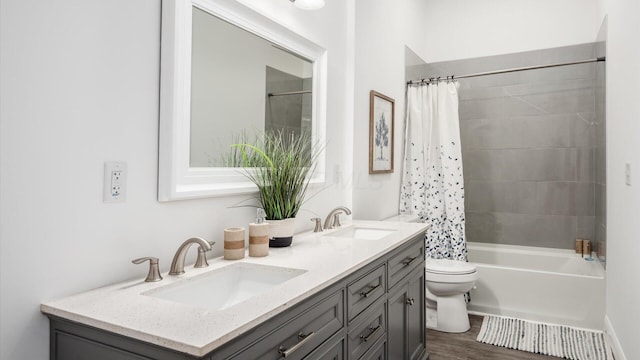bathroom with shower / tub combo, a sink, double vanity, and toilet