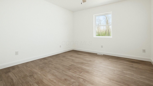 spare room with wood finished floors, baseboards, and ceiling fan