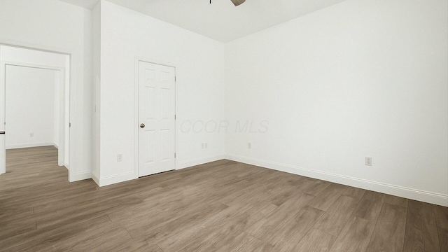 unfurnished room with baseboards, wood finished floors, and ceiling fan