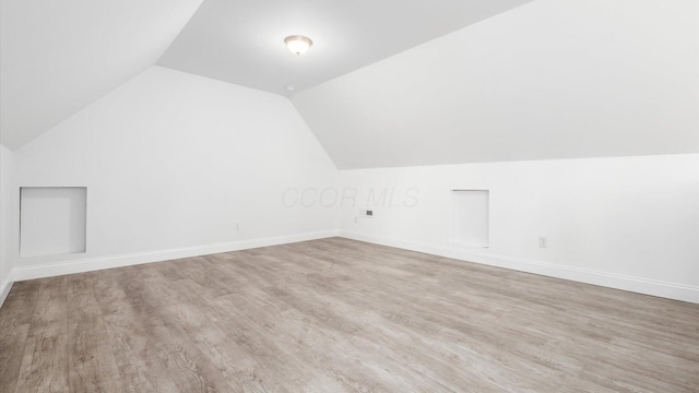 bonus room featuring lofted ceiling, wood finished floors, and baseboards