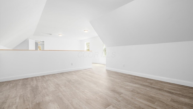 additional living space featuring vaulted ceiling, wood finished floors, and baseboards