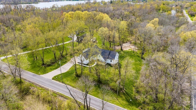 birds eye view of property featuring a forest view and a water view