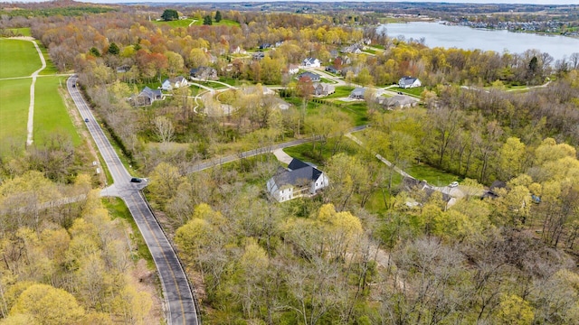 aerial view featuring a forest view and a water view