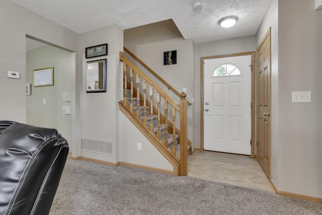 2131 Ripple Rd, Hilliard, OH 43026 - foyer with baseboards, a textured ceiling, stairs, and light carpet