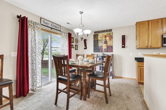 2131 Ripple Rd, Hilliard, OH 43026 - dining area with a textured ceiling, visible vents, light colored carpet, baseboards, and an inviting chandelier