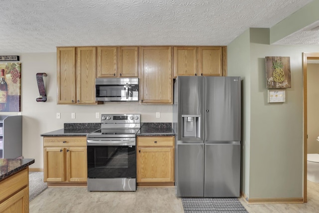 2131 Ripple Rd, Hilliard, OH 43026 - kitchen with appliances with stainless steel finishes, dark stone countertops, and a textured ceiling