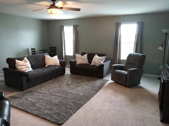 living room featuring a ceiling fan, a wealth of natural light, and carpet floors