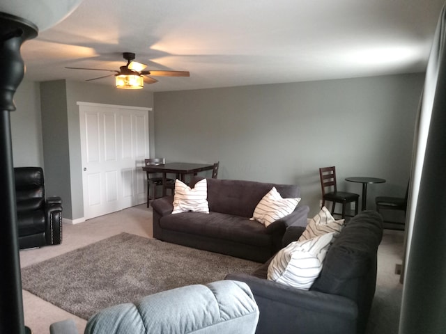 living room with a ceiling fan, baseboards, and carpet floors