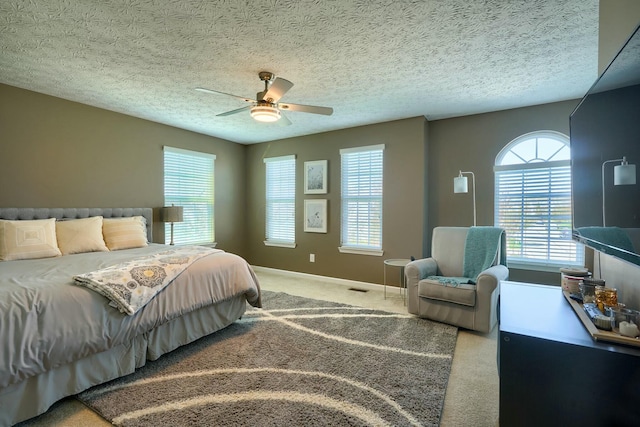 bedroom featuring baseboards, a ceiling fan, a textured ceiling, and carpet