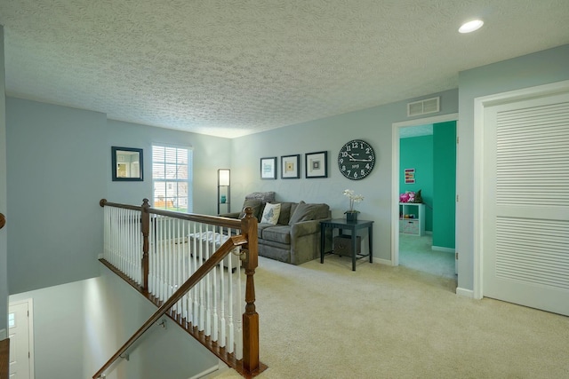 carpeted living room featuring baseboards, a textured ceiling, visible vents, and recessed lighting