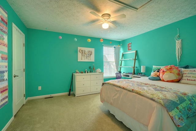 bedroom with light carpet, a ceiling fan, baseboards, and a textured ceiling