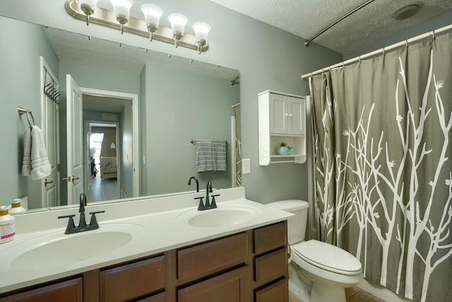 bathroom featuring toilet, a sink, and a textured ceiling