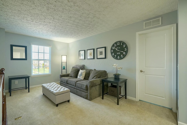 living area with light carpet, baseboards, visible vents, and a textured ceiling