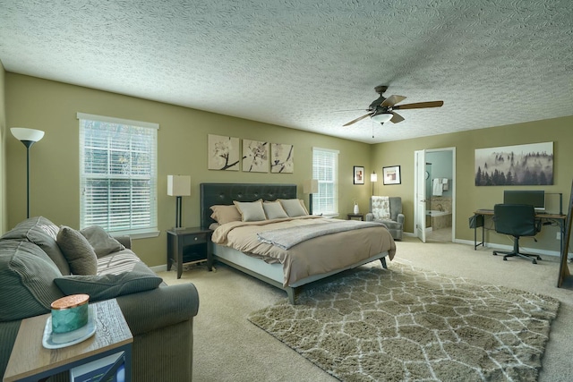 carpeted bedroom with ensuite bath, a ceiling fan, and baseboards