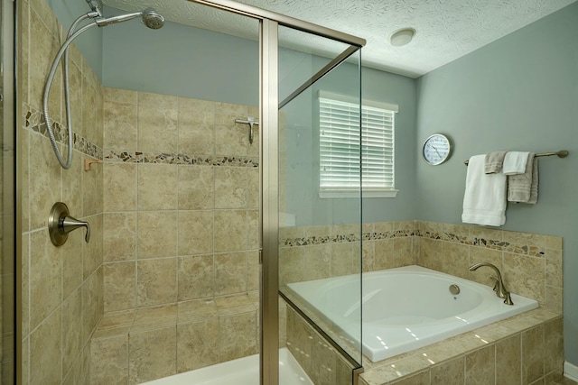 full bathroom featuring a bath, a textured ceiling, and a shower stall