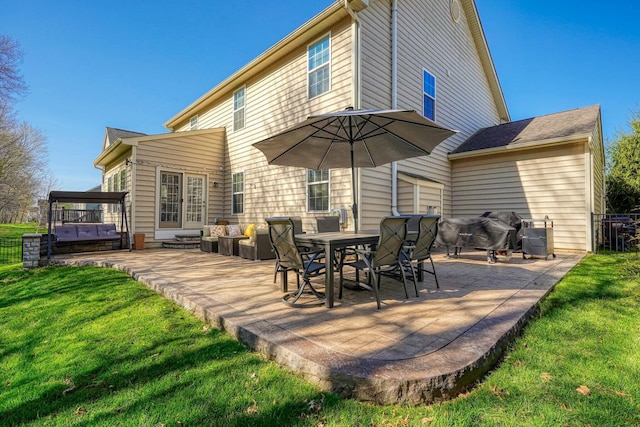 back of property with a lawn and a patio area
