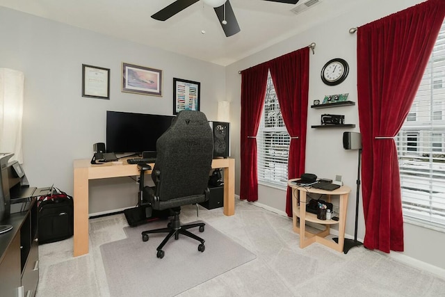 carpeted office with plenty of natural light, a ceiling fan, and visible vents
