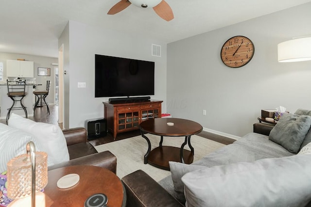 living area with ceiling fan, baseboards, wood finished floors, and visible vents