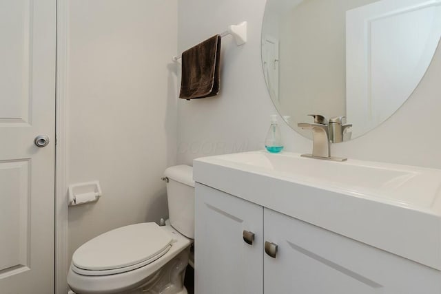 half bath featuring toilet and vanity