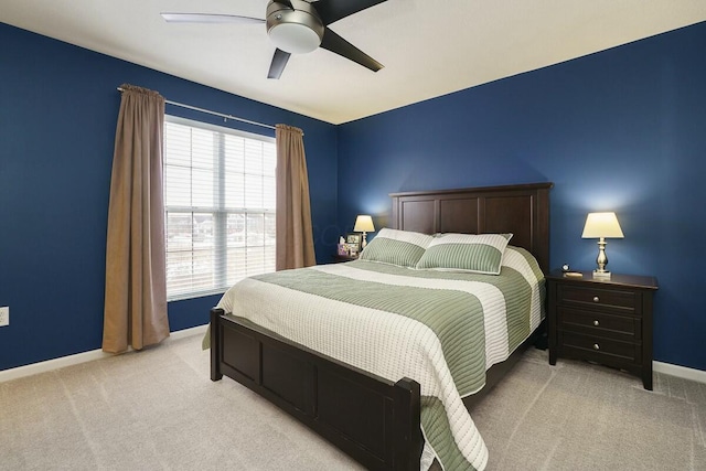 bedroom with a ceiling fan, baseboards, and light colored carpet