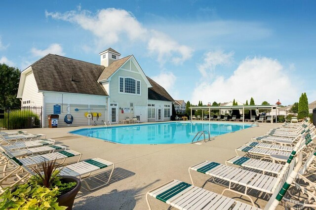 pool with area for grilling, a patio, and fence