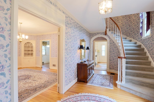 536 E Allen St, Lancaster, OH 43130 - foyer entrance with an inviting chandelier, ornamental molding, wood finished floors, and wallpapered walls