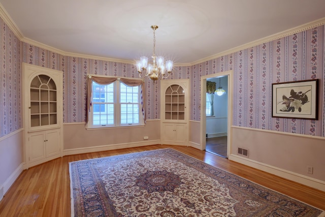 536 E Allen St, Lancaster, OH 43130 - unfurnished dining area with crown molding, a chandelier, wallpapered walls, wood finished floors, and visible vents