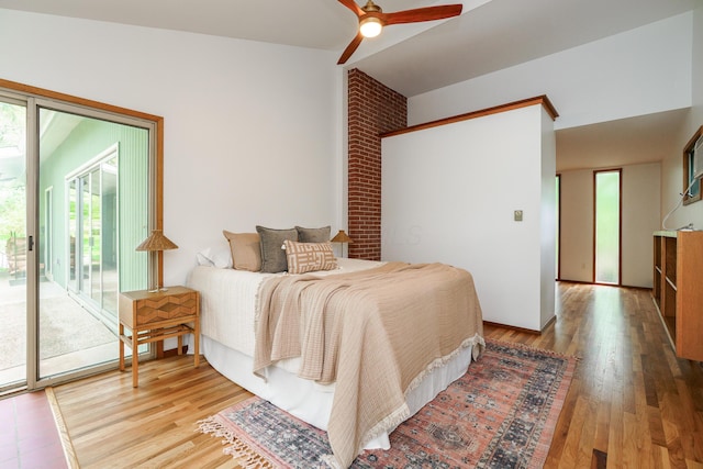 bedroom featuring access to exterior, a ceiling fan, wood finished floors, and vaulted ceiling