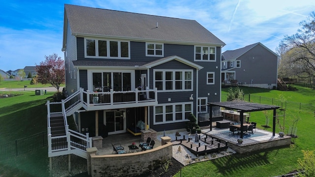 rear view of property featuring a lawn, a wooden deck, and a patio area