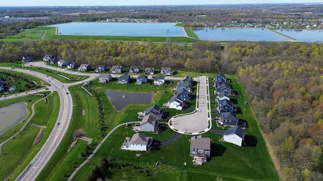 birds eye view of property with a wooded view, a residential view, and a water view